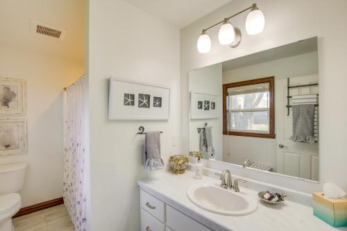 uma casa de banho com um lavatório, um WC e um espelho. em La Petit Maison - Lakefront Oshkosh Home! em Oshkosh