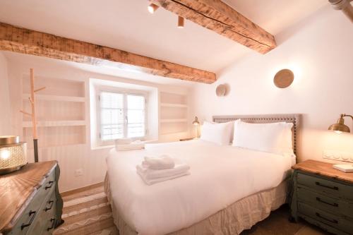 a bedroom with a large white bed and a window at Pick A Flat's Townhouse in Saint-Tropez - Rue Sainte-Barbe in Saint-Tropez
