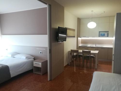 a hotel room with a bed and a table with chairs at Residence all'Adige in Verona