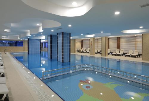 a large swimming pool in a hospital building at Cam Thermal Resort Hotel & Spa in Kızılcahamam