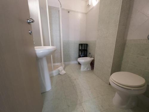 uma casa de banho branca com um WC e um lavatório em B&B Sulmare em Marettimo