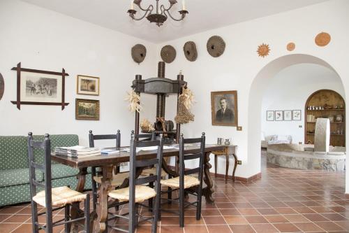 a dining room with a table and chairs at Antico Casale Ruoppo in SantʼAgata sui Due Golfi