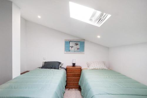 a bedroom with two beds and a dresser in it at Apartamento Cali com Piscina in Apúlia