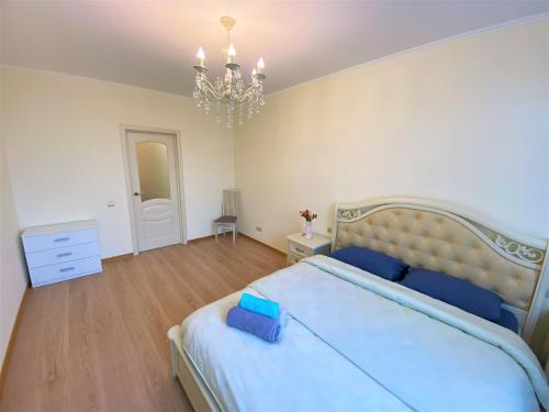 a bedroom with a large bed and a chandelier at FlatService Апартаменти в сучасному ЖК Parklend in Kyiv