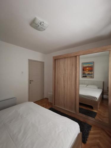 a bedroom with two beds and a large mirror at Art Apartment in Podgorica