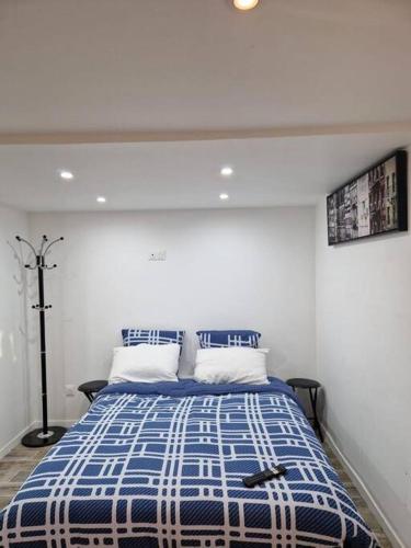 - une chambre dotée d'un lit bleu et blanc avec deux oreillers dans l'établissement Studio paisible CDG/Villepinte/Le Bourget, à Aulnay-sous-Bois