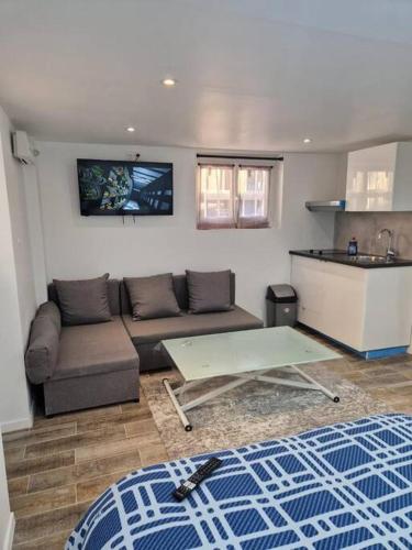 un salon avec un canapé et une table dans l'établissement Studio paisible CDG/Villepinte/Le Bourget, à Aulnay-sous-Bois