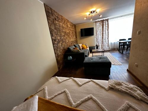 un soggiorno con divano e tavolo di Апартамент НИА a Velingrad