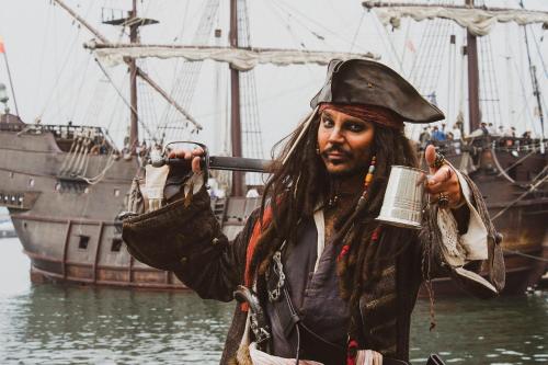 a man in a pirate costume standing in front of a ship at HORTUS HOUSE - Regency style apartment with attached parking in Brixham