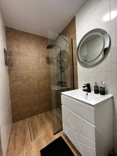 a bathroom with a white sink and a shower at Апартамент НИА in Velingrad