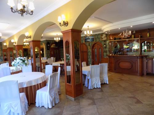 a dining room with white tables and white chairs at Pensjonat Angela in Łeba