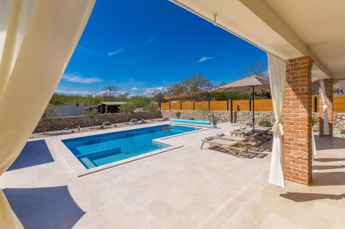 a swimming pool in a yard with a house at Villa QUERCUS in Krk