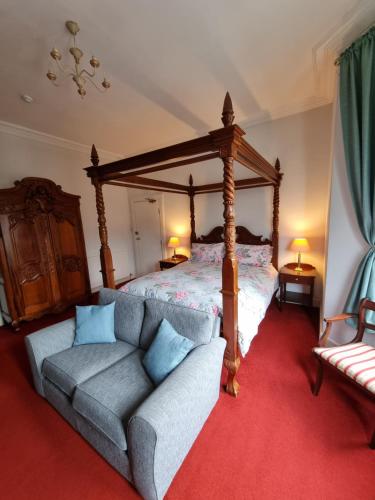 a bedroom with a bed and a couch and a bed at Rowanbank House in Annan