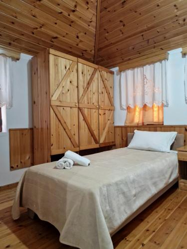 una camera da letto con un grande letto e pareti in legno di Hotel Domino a Gjirokastër