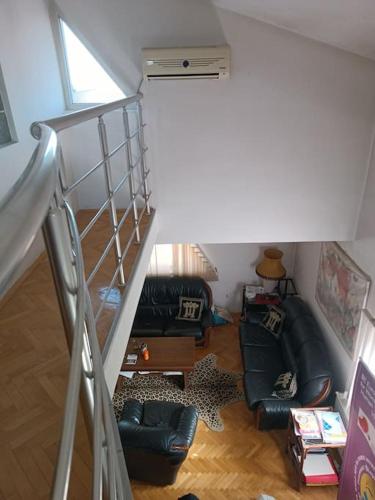 a living room with a couch and a staircase at Vranje City Center, Penthouse Delux Apartment in Vranje
