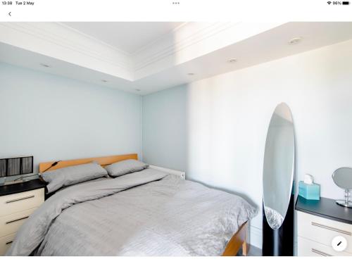- une chambre blanche avec un lit et un miroir dans l'établissement The Copthorne, à Colwyn Bay