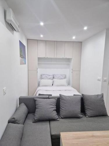 un salon avec un canapé et un lit dans l'établissement Joli studio calme contemporain CDG/PARC D'EXPO VILLEPINTE/PARIS, à Aulnay-sous-Bois