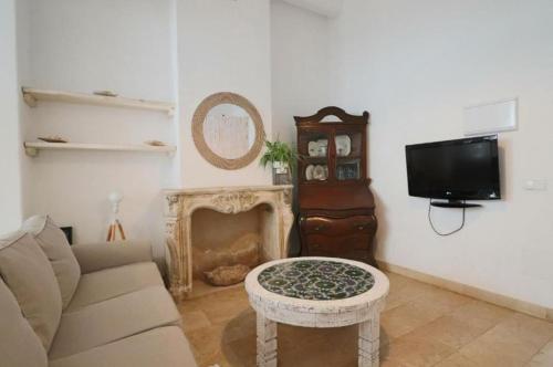 a living room with a couch and a tv and a table at Apartamentos Castillo Quince in Cartaya