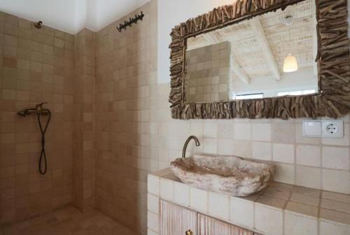 a bathroom with a stone sink and a mirror at Apartamentos Castillo Quince in Cartaya