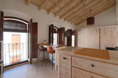 a kitchen with a counter and a table and a window at Apartamentos Castillo Quince in Cartaya