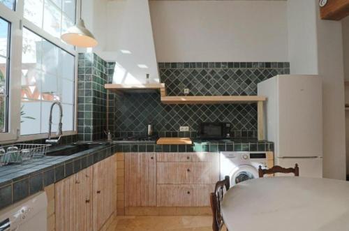 a kitchen with a sink and a washing machine at Apartamentos Castillo Quince in Cartaya