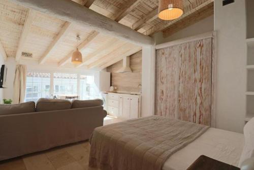 a bedroom with a bed and a couch in a room at Apartamentos Castillo Quince in Cartaya
