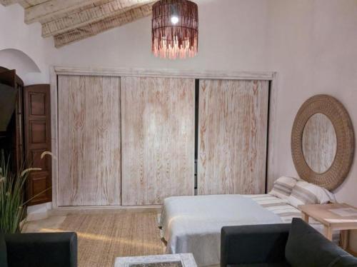 a bedroom with a bed and a couch and a chandelier at Apartamentos Castillo Quince in Cartaya