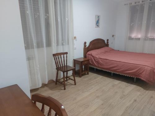 1 dormitorio con 1 cama, 1 silla y 1 mesa en Casa Rural Gerardo, en Armallones