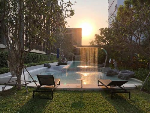 a fountain in the middle of a yard with two chairs at At Huahin in Hua Hin