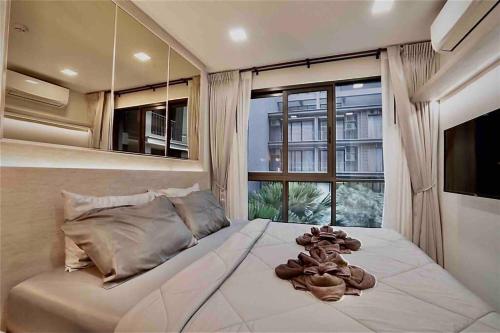 um quarto com uma cama grande e uma janela grande em Huahin Stay em Hua Hin