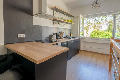 une cuisine avec un comptoir en bois et une fenêtre dans l'établissement La Petite Escale, à Avignon