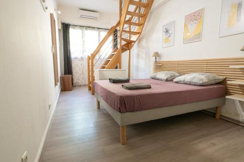 - une chambre avec un lit et un escalier en bois dans l'établissement La Petite Escale, à Avignon