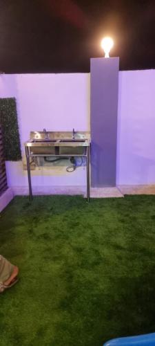 a ping pong table in a room with green grass at Smart Chalet:سمارت شالية in Salalah
