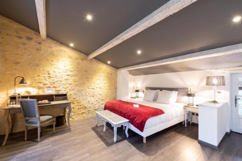 a hotel room with a bed and a desk and a desk at Le Domaine Du Colombier in Malataverne