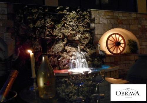 a fountain in a stone wall with a bottle of wine at Obrava Guesthouse Kotroni Trikalon in Kotrónion