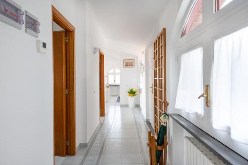a hallway with white walls and white floors and windows at SorrentoVibes - Sea view Rooftop Apartment with Jacuzzi & Garden in Sorrento