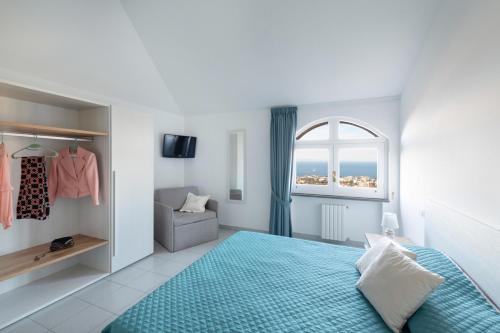 a bedroom with a blue bed and a window at Sea view Rooftop Apartment with Jacuzzi & Garden in Sorrento