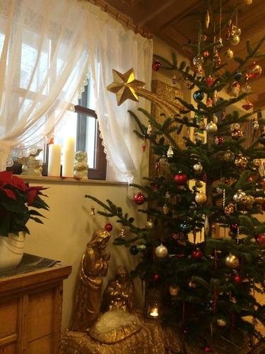 a christmas tree in the corner of a room at Piccolo Hotel Gurschler in Maso Corto