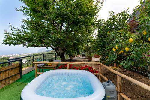 a bath tub on a balcony with a tree at SorrentoVibes - Sea view Rooftop Apartment with Jacuzzi & Garden in Sorrento
