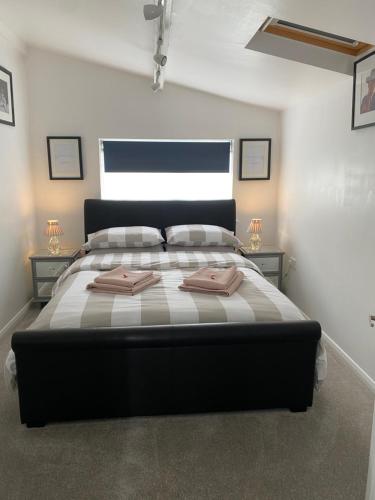 a bedroom with a large bed with two towels on it at Self-contained, Framlingham Snug, Private Parking, no cooking facilities in Framlingham