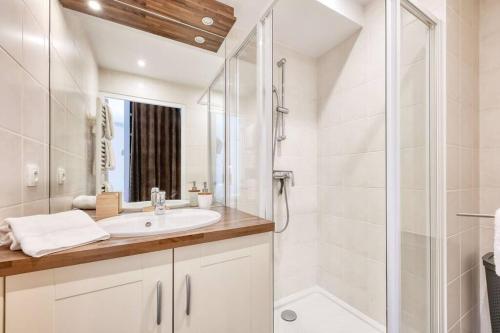 a white bathroom with a sink and a shower at La Collection - Le Village in Saint-Gervais-les-Bains