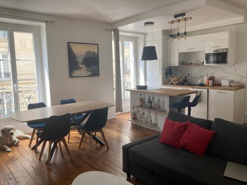 un salon avec un canapé et une table avec des chaises dans l'établissement Appartement 3 pièces Paris 11e, à Paris