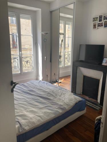 une chambre avec un lit et une cheminée dans l'établissement Appartement 3 pièces Paris 11e, à Paris