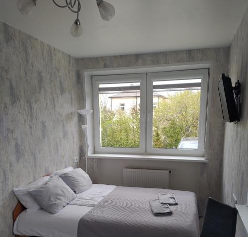 a bedroom with a bed and a window at Poilsis Palangoje pas Daivą in Palanga