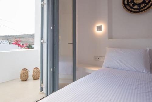 a bedroom with a white bed and a window at ABA Ηospitalité Paros- The Luxury Suite, Naousa, Paros in Naousa