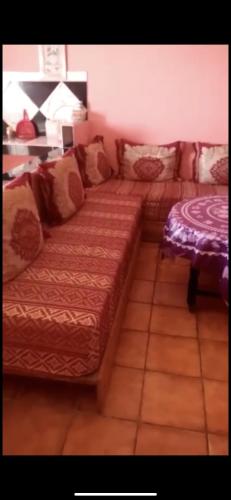 a couch sitting in a living room with a table at مهدية تجزئة العامرية in Kenitra