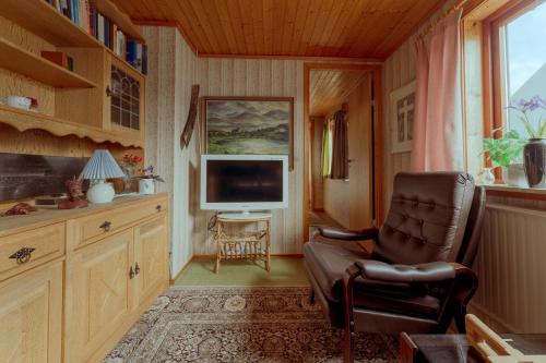 a living room with a chair and a television at 3-Bedroom Home in Eiði 