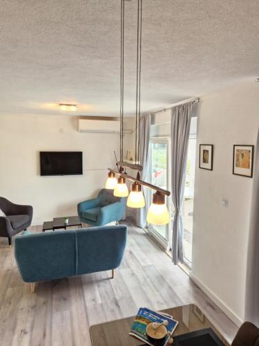 特羅吉爾的住宿－Apartments Silva，客厅配有蓝色的沙发和电视