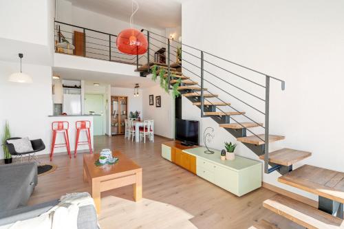 una sala de estar con una escalera en un loft en Apartamento Welcs EMP 063 Frente al Canal con Terraza en Ampuriabrava