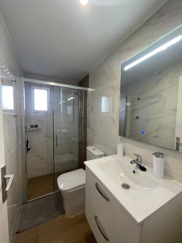 ein Bad mit einem Waschbecken, einer Dusche und einem WC in der Unterkunft Apartamento Welcs EMP 065 cerca del Mar in Roses